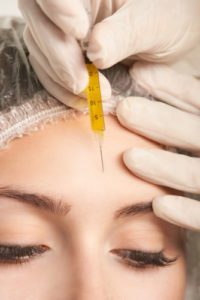 Woman receiving an injection into her forehead